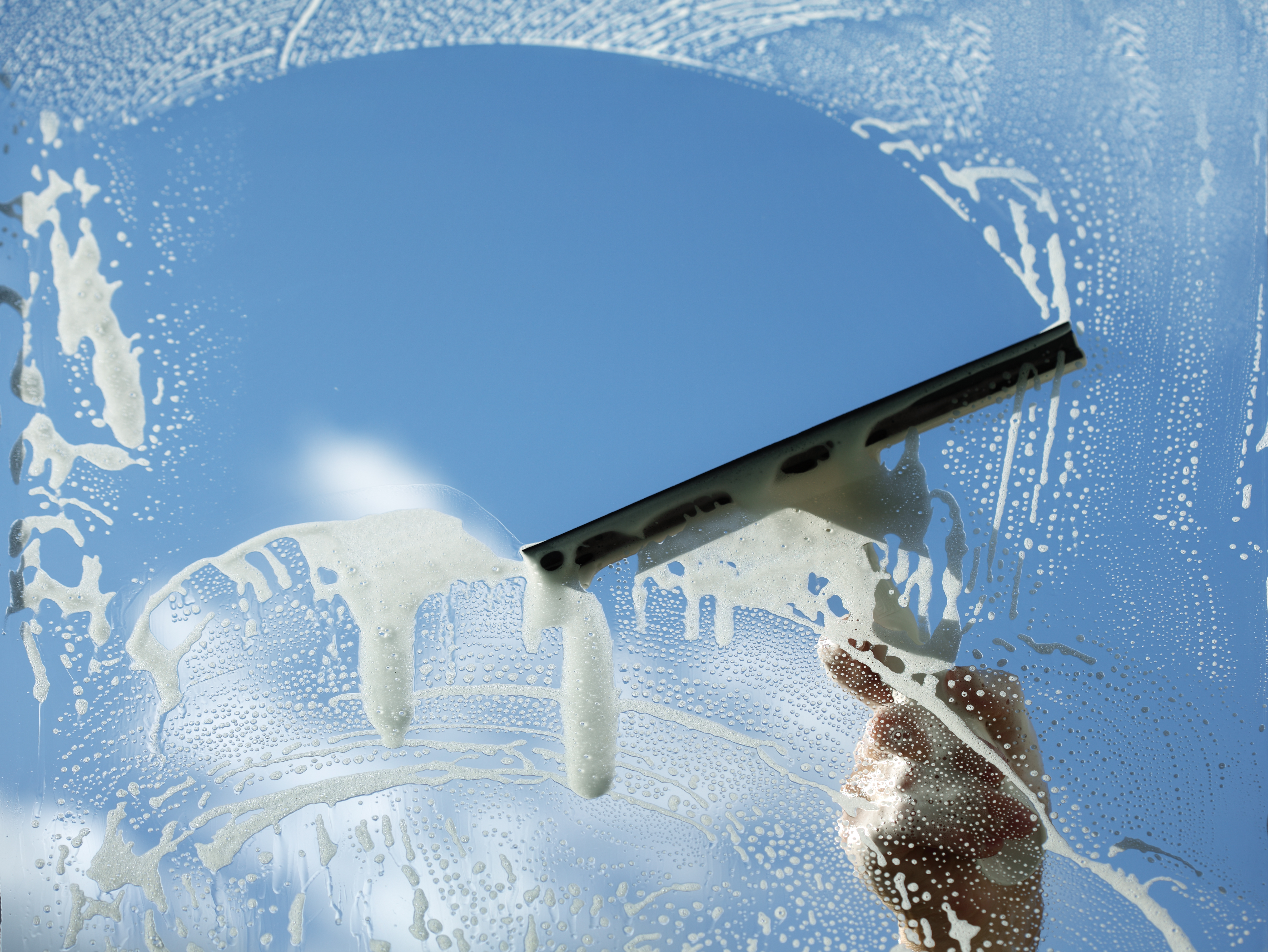 Squeegee clearing soapy water from a window